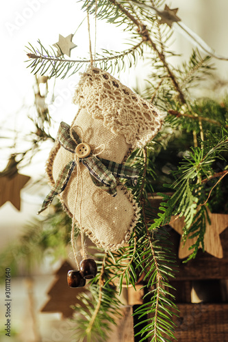 Rustic natural background. Handmade Christmas decorations hang on a Christmas tree. The concept of the new year, christmas and winter holidays. photo