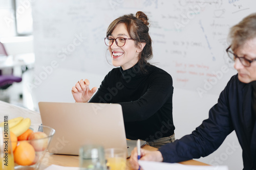 Bilde på lerret Candid portrait of beautiful female marketing expert working on new ideas within creative team during a meeting in office