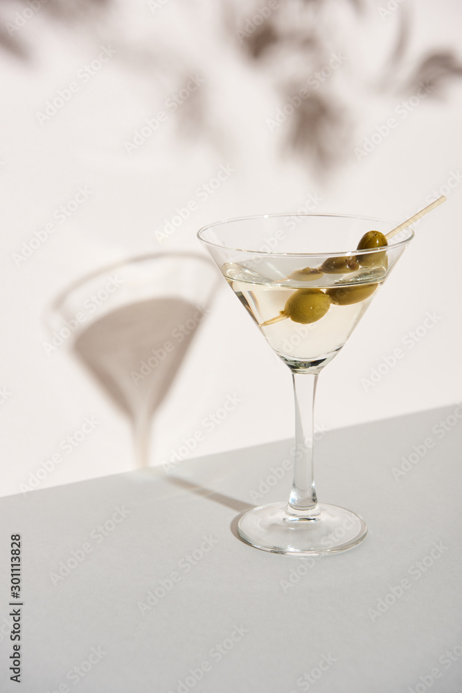 Martini with olives on white background with shadow