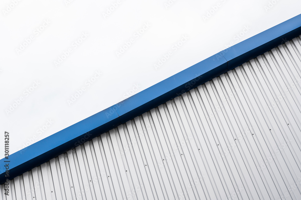 Metal corrugated sheets on a building with a blue metal corners. White