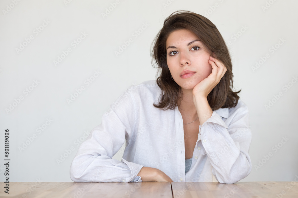 Portrait of a pretty young woman with dark hair on a neutral background. Portrait of a pretty young woman with dark hair on a neutral background.