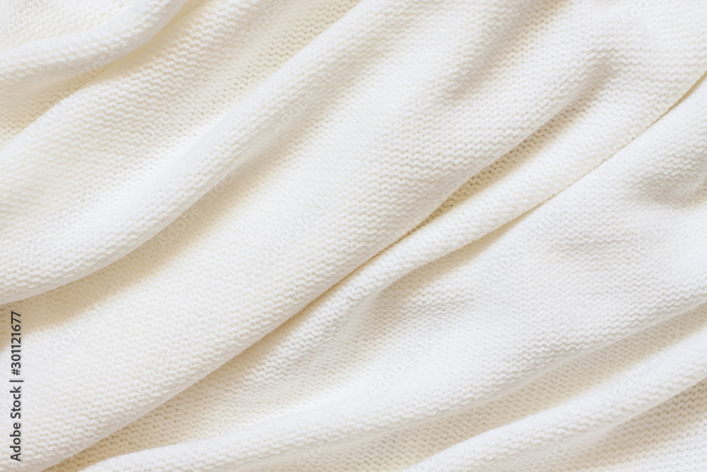 Knitted fabric background, purl stitch pattern, soft white woolen clothes Knitted fabric background, purl stitch pattern, soft white woolen clothes
