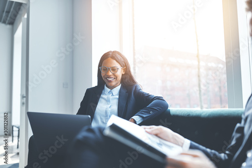 Young African American businesswoman smiling with colleagues dur photo