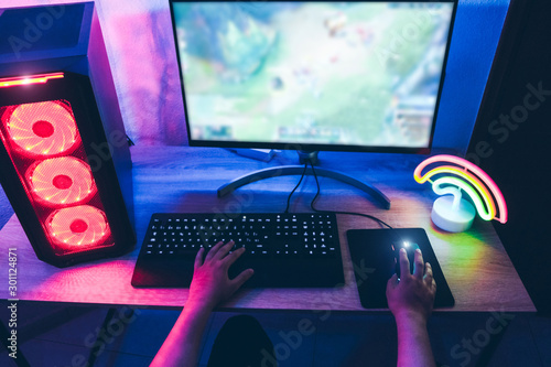 Принти на полотні Young gamer playing at strategy online game - Male guy having fun gaming and str