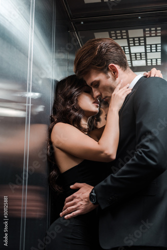 beautiful seductive couple hugging and kissing in lift