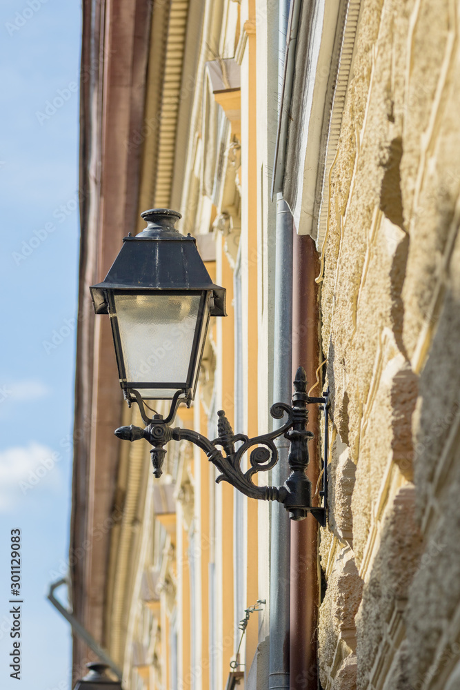 Vintage forged street lamp on the facade of the old house