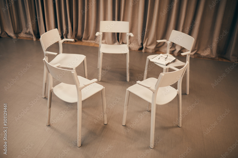 Image of white chairs standing in circle in the room they prepared for the meeting