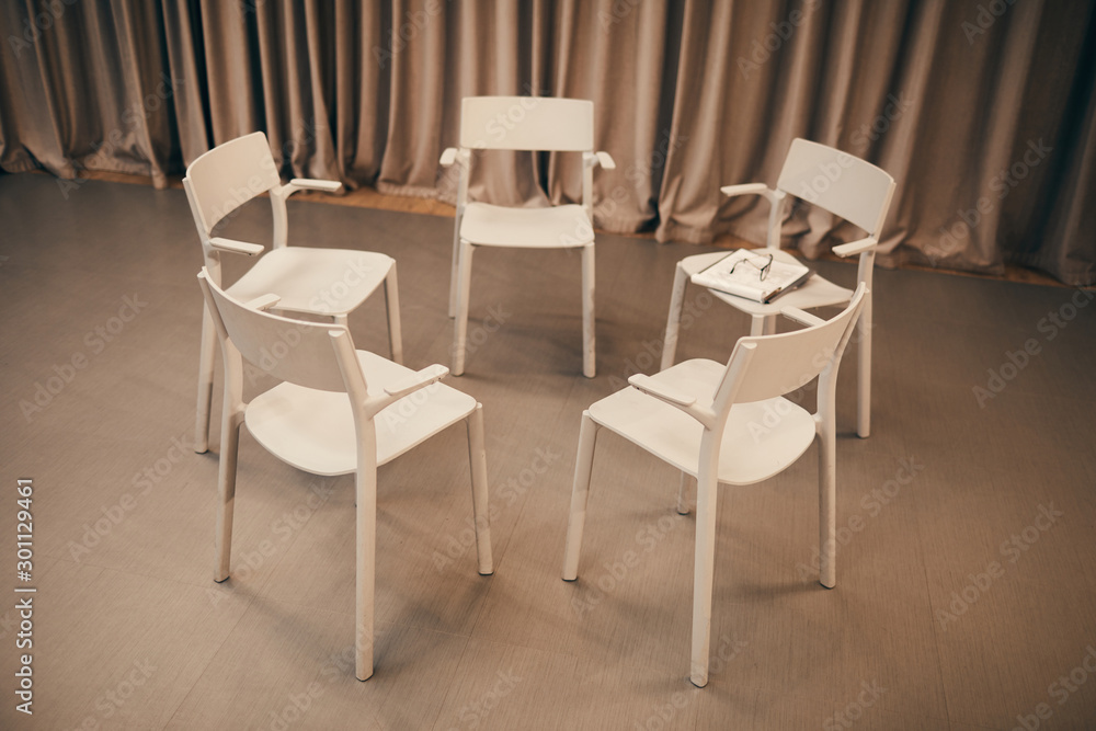 Image of white chairs standing in circle in the room they prepared for the meeting Image of white chairs standing in circle in the room they prepared for the meeting