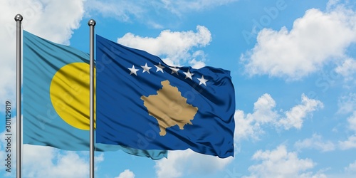 Palau and Kosovo flag waving in the wind against white cloudy blue sky together. Diplomacy concept, international relations.