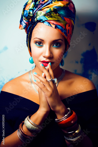 beauty bright african woman with creative make up, shawl on head like cubian closeup smiling photo