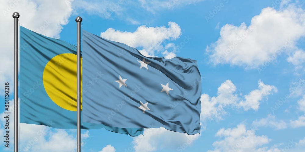 Palau and Micronesia flag waving in the wind against white cloudy blue sky together. Diplomacy concept, international relations. Palau and Micronesia flag waving in the wind against white cloudy blue sky together. Diplomacy concept, international relations.