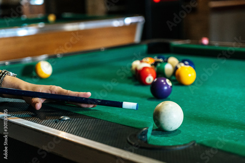 Beautiful smiling women playing billiards at a bar