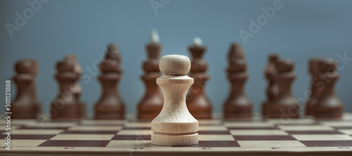 Canvas Print Alone against everyone, chess white pawl against opposite army on gray background