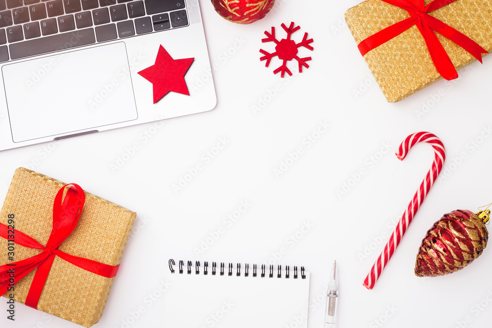 Fototapeta premium Preparing for Christmas: laptop, daily planner, cup of coffee, gifts, and decorations on the white background. Top view. Space for a text.