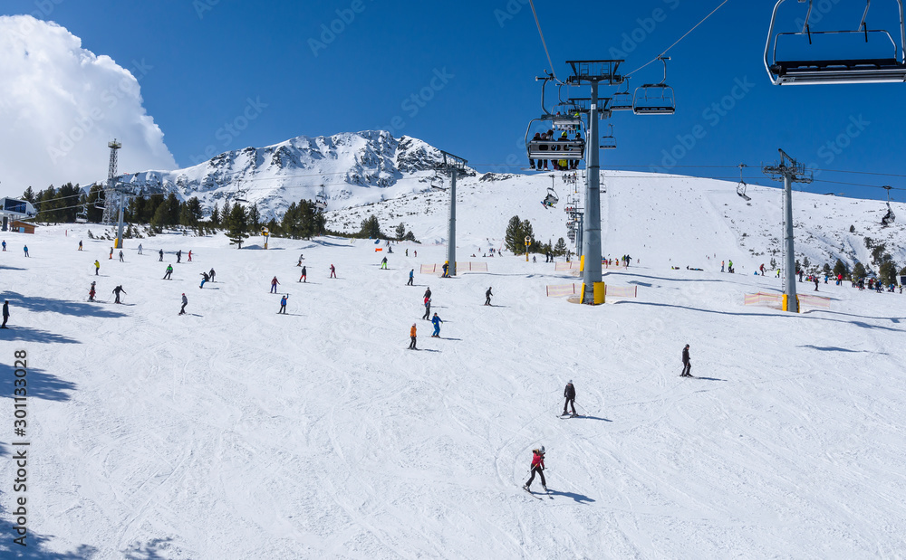 Chair lift to the Todorka peak and skiers on the slope