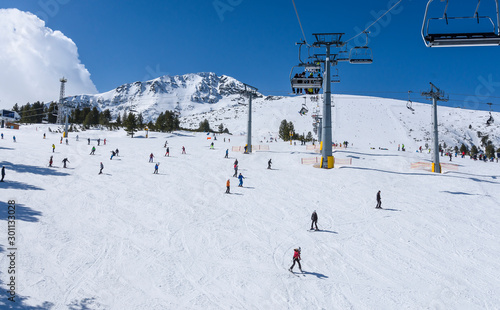 Chair lift to the Todorka peak and skiers on the slope