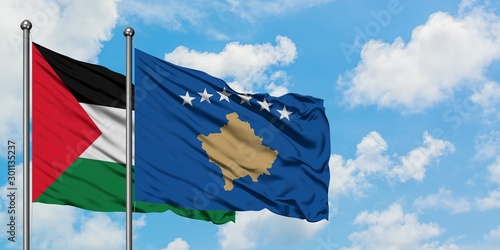 Palestine and Kosovo flag waving in the wind against white cloudy blue sky together. Diplomacy concept, international relations.