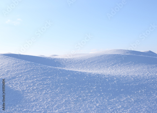 A large beautiful snowdrift and blue sky. Winter landscape. A big snow drift