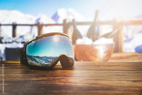 Fotografie apres ski - goggles with mountains reflection on the restaurant table at ski res