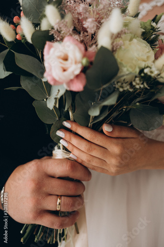wedding bouquet in the hands of the bride and groom