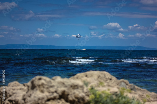 Parachute in the sky over the sea, waves, sunny day and holidays