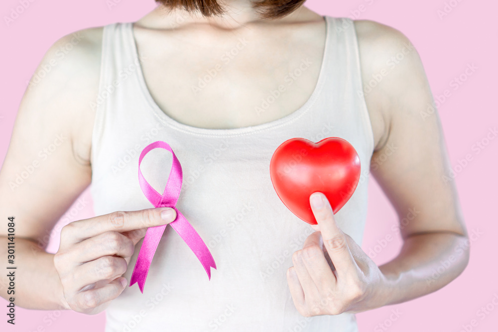 breast cancer concept with woman hand showing pink ribbon and heart breast cancer concept with woman hand showing pink ribbon and heart