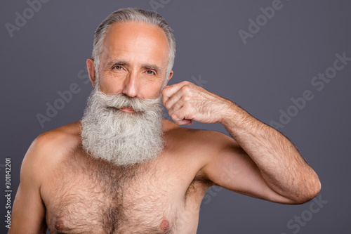 Photo of joyful condifent old man demonstrating his tight fit rejuvenated isolated over grey color background