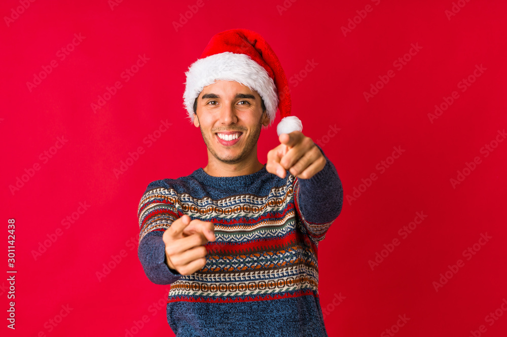Young man on christmas day frowning face in displeasure, keeps arms folded. Young man on christmas day frowning face in displeasure, keeps arms folded.