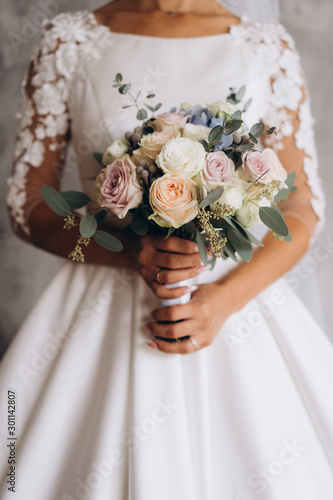 the bride’s bouquet in the bride’s hands, wedding details, selective focus, film and grain photo