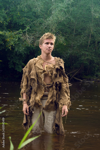 Medieval peasant man in river - downshifting concept