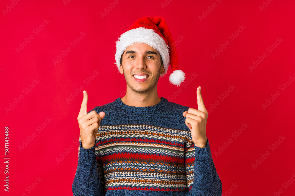 Young man on christmas day laughs happily and has fun keeping hands on stomach. Young man on christmas day laughs happily and has fun keeping hands on stomach.