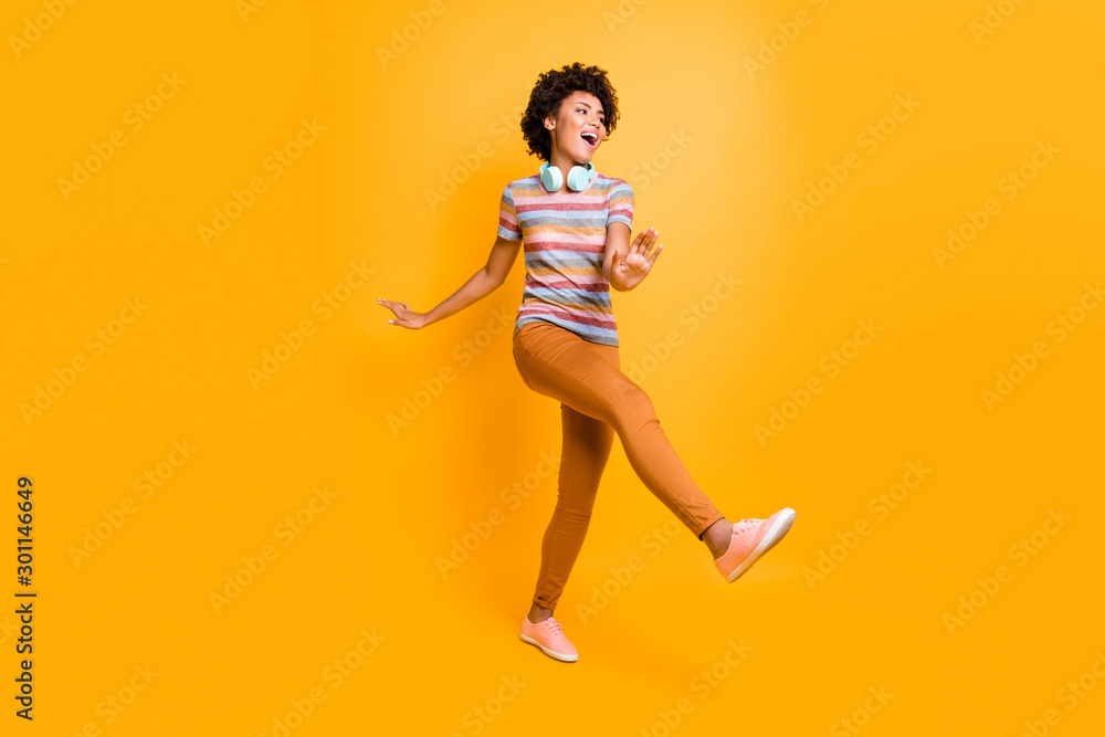 Full body photo of positive cheerful crazy brown hair girl have headset listen radio melody song music dance feel content expression wear casual style outfit isolated yellow color background Full body photo of positive cheerful crazy brown hair girl have headset listen radio melody song music dance feel content expression wear casual style outfit isolated yellow color background