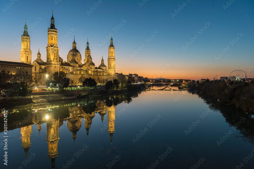 View of the cathedral of El Pilar de Zaragoza (Spain) next to the river Ebro, at dusk.
