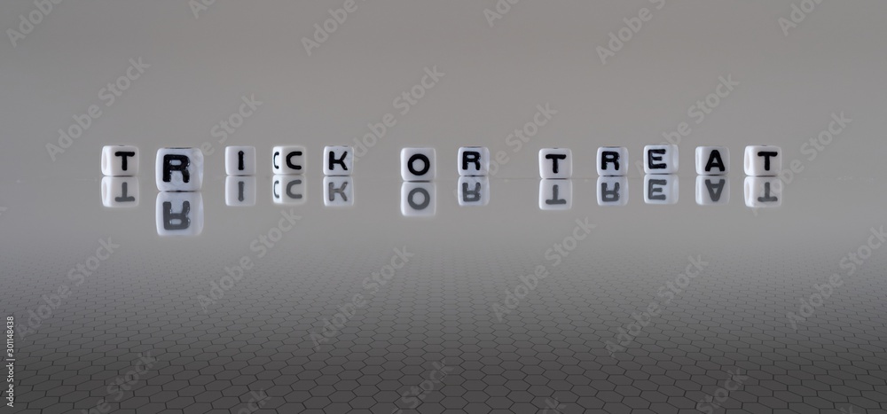 The phrase Trick Or Treat represented by black letters on white cubes with a grey background The phrase Trick Or Treat represented by black letters on white cubes with a grey background