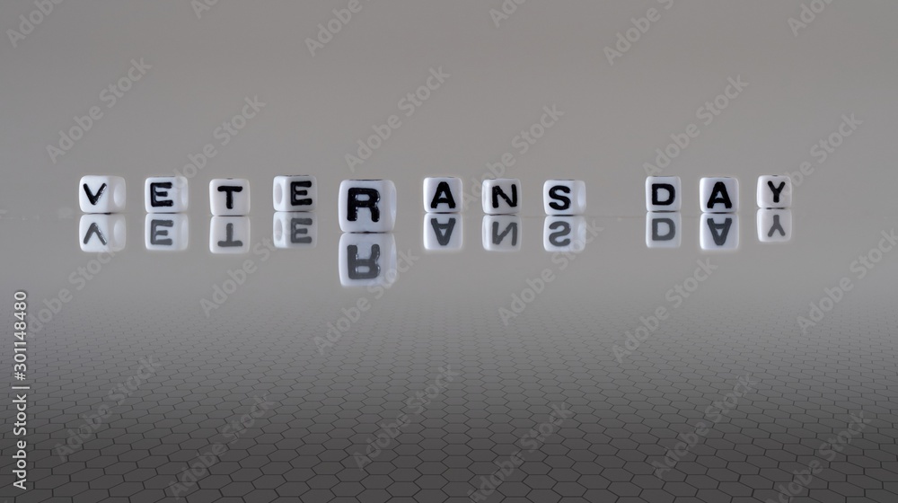 The phrase Veterans Day represented by black letters on white cubes with a grey background The phrase Veterans Day represented by black letters on white cubes with a grey background