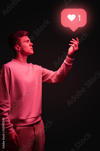 Man holding instagram like icon in hand on black background