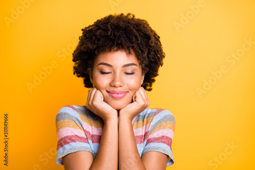 Photo of cheerful cute charming fascinating black youngster with eyes closed enjoying her free time isolated over yellow vivid color background