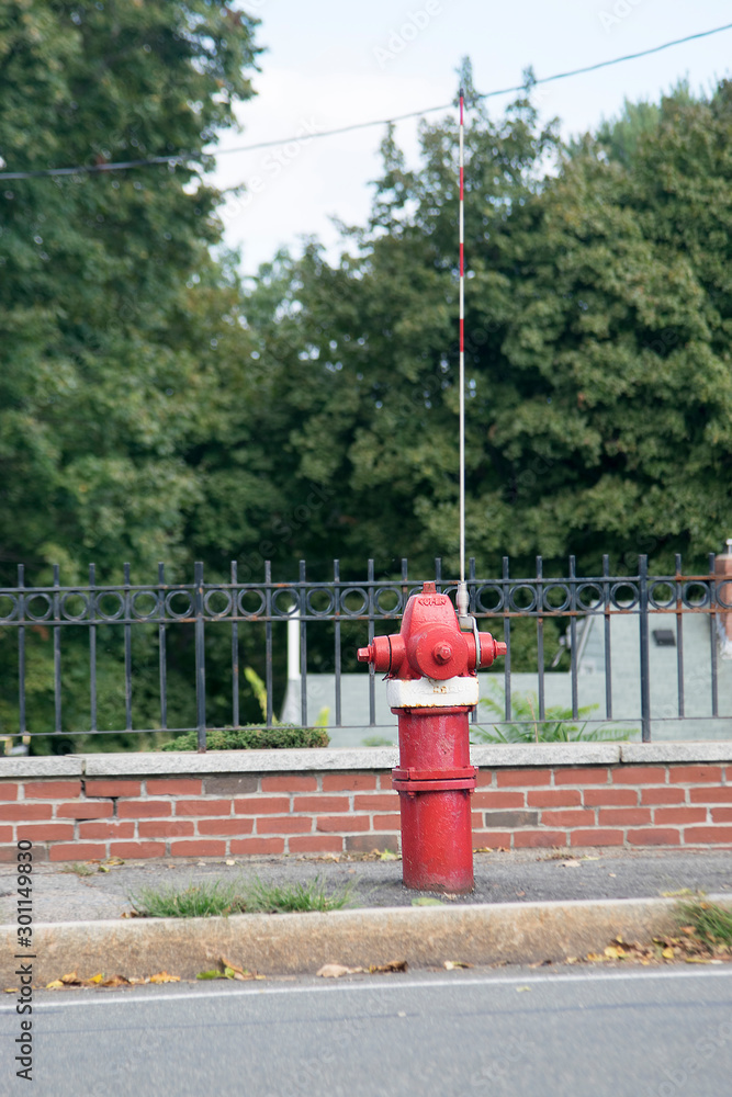 FIRE HYDRANT with an arrester in a residential area painted in red and white colors FIRE HYDRANT with an arrester in a residential area painted in red and white colors