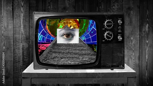 Zoom then fixed shot on retro TV, pyramid eye conspiracy imagery photo