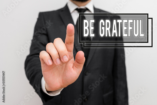 Text sign showing Be Grateful. Business photo showcasing feeling or showing an appreciation for something received Male human with beard wear formal working suit clothes raising one hand up