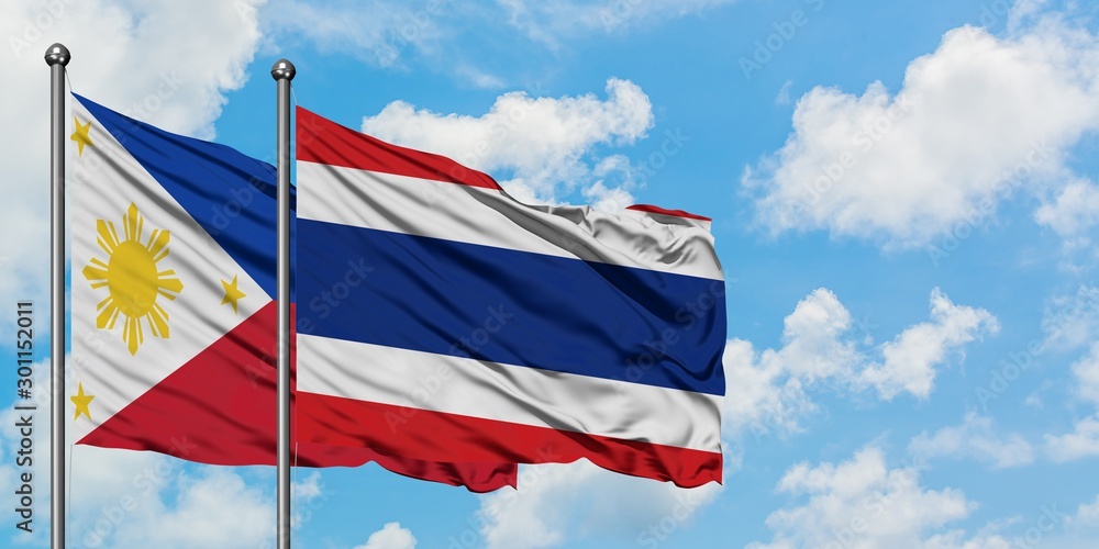Philippines and Thailand flag waving in the wind against white cloudy blue sky together. Diplomacy concept, international relations.
