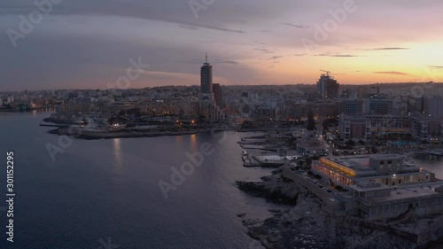 High Aerial shot orbiting around the coast of St Julians Malta. Baech at the sunset photo