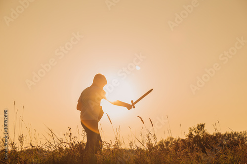 Happy confident young kid playing outdoor in summer sunny sunset landscape. Setting goals and aims concept. Horizontal color photography.