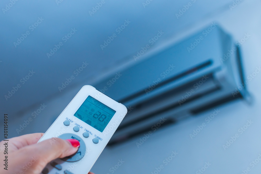 remote control from the air conditioner in a woman's hand remote control from the air conditioner in a woman's hand