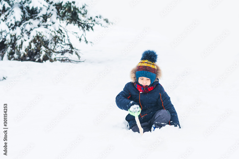 boy playing with a shovel in the snow boy playing with a shovel in the snow