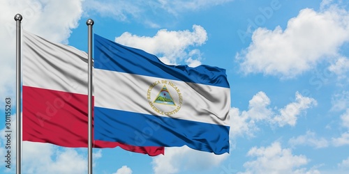 Poland and Nicaragua flag waving in the wind against white cloudy blue sky together. Diplomacy concept, international relations.