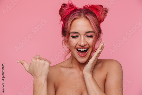 Portrait of attractive shirtless young woman pointing finger at copyspace