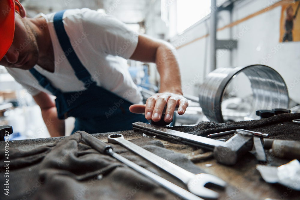 Tools on the table. Man in uniform works on the production. Industrial modern technology Tools on the table. Man in uniform works on the production. Industrial modern technology