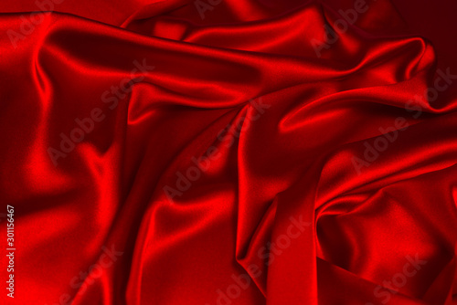 Red silk or satin luxury fabric texture can use as abstract background. Top view.