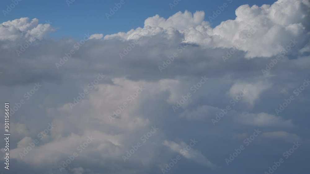 Above the clouds and blue sky view from airplane window, no color grade handheld shot Above the clouds and blue sky view from airplane window, no color grade handheld shot